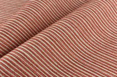 an orange and white striped fabric with vertical stripes on it's surface, close up