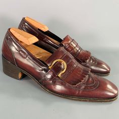 Salvatore Ferragamo Loafers In A Burgundy Leather Featuring A Perforated Style With Wingtip Design, Tassel Details, And Gold Tone Ferragamo Buckle. Shoe Trees Not Included. Made In Italy.Excellent Pre-Owned Condition. Marked: Ug52482 C 15 8 Doutsole: 11.25 Inches X 3.75 Inches Sui Generis Reference: 132410 Category: Loafers More Details Brand: Salvatore Ferragamo Gender: Male Size: 8 Color: Burgundy Color 2: Gold Pattern: Perforated Fabric: Leather Style: Wingtip Made In: Italy Age Group: Adult Vintage Business Tassel Loafers Slip-on, Vintage Tassel Loafers For Business, Vintage Tassel Slip-on Loafers For Business, Vintage Formal Tassel Loafers Slip-on, Leather Shoes With Brogue Detailing For Fall Galas, Vintage Tassel Loafers For Formal Occasions, Vintage Tassel Loafers Slip-on For Formal Occasions, Vintage Tassel Slip-on Loafers For Formal Occasions, Vintage Formal Slip-on Loafers