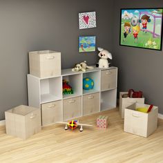 a child's playroom with toys and storage boxes on the floor in front of a gray wall