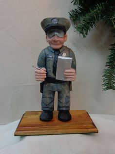 a figurine of a soldier holding a clipboard in his right hand and looking at the camera