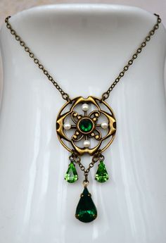 "VINTAGE ELEMENTS Unique Jewellery, Handmade from Vintage Inspired , Original Designs Edwardian, Victorian, Art Nouveau, Art Deco style antiqued Brass Necklace with Emerald and Peridot Green glass drops. This necklace has a fine, elegant, antiqued brass chain and measures 17 1/4\" (44cm) from end to end with a 2 1/2\" (6cm) extender chain." Vintage Antique Gold Jewelry With Historical Design, Vintage Brass Jewelry With Historical Design, Vintage Baroque Jewelry With Historical Design, Vintage Jewelry With Historical Design As Gift, Vintage Jewelry With Historical Design For Gift, Vintage Pendant Necklace With Historical Design, Vintage Necklace With Historical Design For Gift, Victorian Round Necklace With Antique Finish, Vintage Wedding Necklaces With Antique Finish