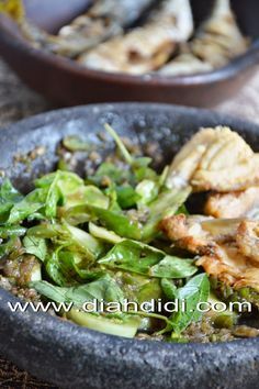 a bowl filled with meat and vegetables on top of a table