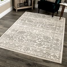 a living room with hardwood floors and a rug on the floor