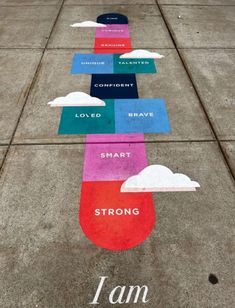 the sidewalk has many different colors and words painted on it, including one that says i am