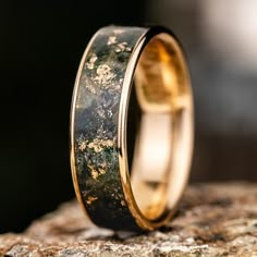 a close up of a wedding ring on top of a rock with moss growing on it