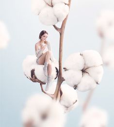 a woman sitting on top of a cotton plant