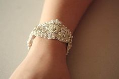 Vintage inspired beading gives a nostalgic picturesque look to every wedding attire. Each piece is carefully handcrafted using opulent swarovski stones and silk thread, making it a perfect heirloom piece. * Bracelet with Swarovski rhinestone and intricate embroidery * Ivory and off-white pearl beading with silver metallic thread work * Length of the beading section is 6.5 inches and width is about 1.5 inches. Fastening/ Finishing options - please mention the option you prefer upon check out. Opt Vintage White Bracelets For Wedding, Elegant White Beaded Crystal Bracelet, Vintage Beaded Wedding Bracelets, Vintage Jeweled Bracelets For Wedding, Wedding Pearl Bracelet With Beaded Details, Elegant Handmade Crystal Bracelet For Party, Handmade Elegant Crystal Party Bracelet, Handmade Elegant Crystal Bracelet For Party, Adjustable Pearl Embellished Bracelet For Wedding