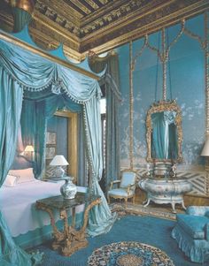 an ornate bedroom with blue walls and curtains