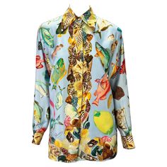 Presenting a baby blue aquatic motif silk button-down Gucci shirt. From the Spring/Summer 1992 collection, this fabulous top appeared on the season's runway and in the season's ad campaign. Covered in shells and different aquatic life, this fabulous shirt is made complete with gold 'GG' Gucci buttons at the neck and cuffs. Approximate measurements: Size - IT38 22.5" shoulder to cuff 19.5" underarm to cuff 28" shoulder to hem 41" bust 41" waist 100% silk Luxury Fitted Gucci Blouse, Gucci Summer Workwear Tops, Luxury Printed Blouse For Spring, Designer Summer Floral Print Shirt, Designer Floral Print Summer Shirt, Designer Patterned Tops For Spring, Designer Printed Tops For Spring, Designer Printed Tops For Summer, Gucci Silk Blouse For Spring