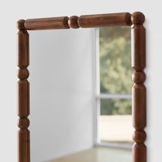 a wooden frame mirror sitting on top of a table