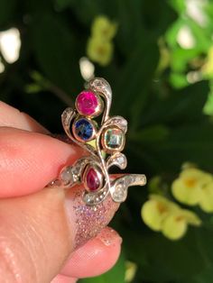 Victorian 14k Rose Gold and Silver Ruby, Sapphire, Emerald and Diamond Flower motif ring  Era: Victorian (1837-1901; the majority of the 19th century) Ring size*: H.25 (UK). Equivalent to 4 (USA) on my ring mandrel. Sizeable: Yes, please organise with your local jeweller. Hallmarked: No Gold test: 14K rose gold  Original: Yes Description: The 14k rose gold and silver setting ring has 4x rose gold bezel settings for the gemstones and 12x silver topped bezel set diamonds in asymmetrical flower des Victorian 14k Gold Diamond Ring With Gemstone, Victorian Multi-stone Ring For Anniversary, Victorian Multi-stone Yellow Gold Diamond Ring, Victorian Multi-stone Yellow Gold Rings, Victorian Multi-stone Ruby Ring For Anniversary, Antique 14k Gold Ruby Ring With Multi-stone, Victorian 14k Gold Ruby Ring, Victorian Style 14k Gold Ruby Ring, Art Nouveau Yellow Gold Rings With Rose Cut Diamonds