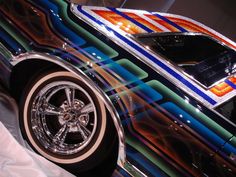 a colorful car with chrome rims on display