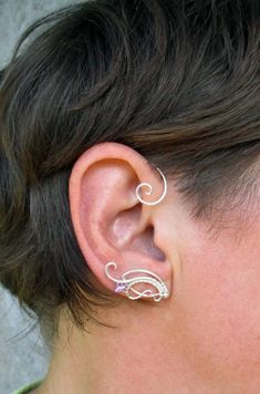 ORDERS PLACED AFTER DECEMBER 1, MAY ARRIVE AFTER CHRISTMAS OR NEW YEAR EVE due to the postal services being overwhelmed this time of year. Average delivery terms USA, France, Ireland - 3-4 weeks Australia, Canada - 4-6 weeks Netherlands, Spain - 2-3 weeks Please message me if you are unsure of dates before ordering. A pair of ear cuffs made of silver plated copper wire, glass and silver plated beads. The piece is covered by metal protecting lacquer. No piercing needed. Made for medium size ears Delicate Silver Cartilage Earrings With Ear Wire, Delicate Ear Cuff As A Gift, Dainty Silver Ear Cuff For Wedding, Dainty Silver Single Ear Cuff, Adjustable Silver Ear Cuff With Ear Wire, Silver Ear Climbers For Wedding, Silver Dainty Ear Cuff With Matching Earrings, Bohemian Silver Ear Climbers As Gift, Silver Ear Cuff For Gift