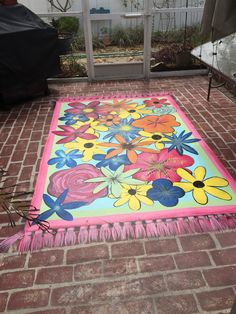 a colorful rug is on the ground in front of a house