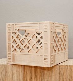 a wooden box sitting on top of a piece of ply wood with holes in it