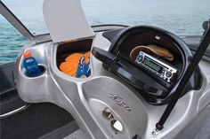 the inside of a motor boat with items in its storage compartment on the front seat