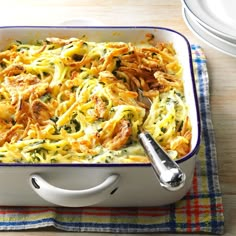 a casserole dish with meat and cheese in it on a plaid placemat