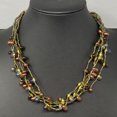 a necklace with multicolored beads on a mannequinn neckline,