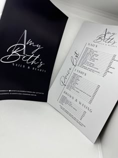 an open brochure is shown on a white tablecloth with black and silver lettering