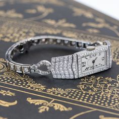 One of the most beautiful, blingy, and absolutely stunning cocktail watches that one could possibly add to one's jewelry suite! Made by the well-known jewelry house JE Caldwell, the watch is studded with antique diamonds, pave-set in platinum. The case is in excellent condition and has been observed to be running. The bracelet is in addition, styled beautifully to complement the case. The perfect accessory to complete any outfit! Platinum with a 14kt white gold bracelet Will fit up to a 6.25" wr Modern Mens Rings, Art Jewelry Earrings, Art Deco Watch, Bespoke Rings, Antique Watches, White Gold Bracelet, Antique Engagement Rings, Art Deco Diamond, Vintage Band