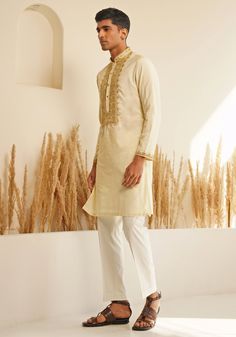 Presenting the Ivory And Gold Silk Kurta Set with a chinese collar for elegance and metallic golden buttons for a unique detail. The hand embroidered details on the neckline and cuffs make it stand out. Teamed with elegant white pants. Perfect for an Engagement, Roka or Wedding Reception. Composition : Chanderi Silk Care: Dry Clean Only and Vacuum Storage This product can be customized for sleeves, length and colour Delivery : 4-6 weeks as the product is hand crafted. Check Size Guide or choose MySize for free customisation (All Sizes above XL can be made at 15% additional cost) For more information and sizes please contact fabiliciousfashion@gmail.com or visit our Copenhagen studio. About the Designer : Shreyansh, a distinguished designer label specializing in luxurious ethnic menswear fo