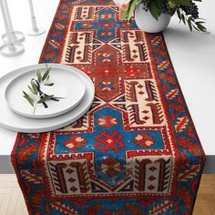 a table with a red and blue runner on top of it next to a white plate