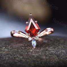 a ring with an orange and blue stone in the center on top of a rock