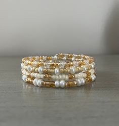 This memory wire bracelet with gold seed beads is a great option for bridal accessories or other special occasions. This bracelet wraps around the wrist giving the appearance of multiple bracelets, though it is one piece. Beads are glass and multi sized, but small making this low weight and comfortable.  Memory wire is flexible and strong. This bracelet measures 7 inches around but will stretch a bit to a bigger size. For small wrists, this will hang like a bangle. Gold Wrap Bracelet With Tiny Beads As A Gift, Dainty Handmade Gold Beaded Bracelets, Elegant Wrap Bracelet With Tiny Beads As A Gift, Elegant Wrap Bracelet With Tiny Beads For Gift, Bohemian Gold Wrap Bracelet With Tiny Beads, Bohemian Gold Beaded Stretch Bracelet, Dainty Gold Beaded Bracelet, Gold Beaded Stretch Bangle Bracelet, Gold Multi-strand Stackable Bracelets