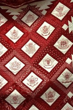 a red and white quilt with many different designs on it