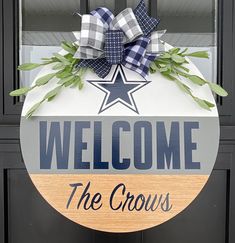 a welcome sign hanging on the front door of a building with a star and plaid bow