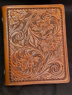 a brown leather wallet sitting on top of a black surface