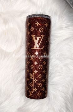 the louis vuitton glitter tumbler is sitting on a white fur covered surface