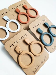 four pairs of clip - on earrings are shown in three different colors and shapes, one is blue, the other is brown