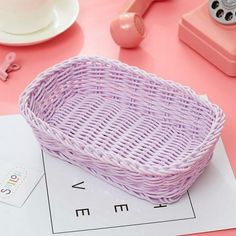 a purple basket sitting on top of a table next to a cup and saucer