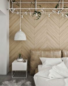 a white bed sitting under a wooden wall next to a night stand with plants on it