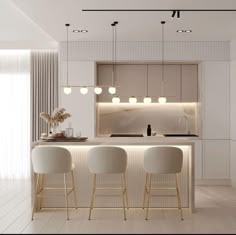 a white kitchen with three bar stools next to the counter and lights above it