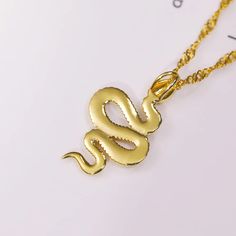 🐍 Embrace the allure of the serpent with our Year of the Snake Gold Necklace – a stunning piece that weaves elegance and symbolism into your everyday style! Available in both 18K gold over titanium steel, this necklace captures the essence of sophistication and durability. The sleek design features a captivating Singapore chain, offering versatility that allows you to wear it flat for a classic look or twisted for a contemporary twist. The 20-inch chain, complete with a 2-inch extension, ensure Metal Snake-shaped Jewelry With Adjustable Chain, Snake-shaped Metal Necklace For Gift, Metal Snake Shape Necklace As Gift, Metal Snake-shaped Necklace For Gift, Luxury Gold Plated Snake Chain Necklace, Metal Snake-shape Chain Necklace As A Gift, Snake Shape Metal Chain Necklace For Gift, Metal Snake Shape Chain Necklace For Gift, Gold Snake-shape Chain Jewelry