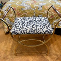 a leopard print upholstered chair sitting on top of a hard wood floor