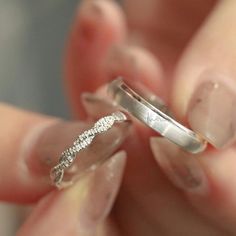 a woman holding two wedding rings in her hand