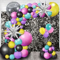 balloons, stars and disco balls are arranged in the shape of an arch for a birthday party