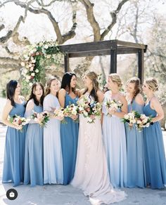 a group of women standing next to each other in front of a wooden gazebo