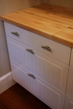 a wooden counter top sitting on top of a white dresser