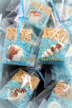 some cookies are wrapped in plastic and sitting on top of each other with blue ribbons