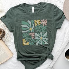 Retro Boho Flowers T-shirt, Boho T-shirt, Floral T-shirt, Botanical T-shirt, Abstract Shirt, Hippie T-shirt (S-2XL) is printed on a favorite Bella Canvas 3001 unisex t-shirt, that is soft, lightweight and comfortable. Designed in Northern Maine. Made to Order in the USA.  * Colors may differ from screen due to lighting. * 100% Combed & Ring-Spun Cotton (Heather Colors Contain Polyester) * Fabric Weight: 4.2 oz./yd.² * Pre-Shrunk Fabric * Unisex, Regular Fit (Size up for a looser fit) * Side-Seamed Construction * Shoulder-to-Shoulder Taping * Blank Product Imported * Designed in Northern Maine * Direct to Garment Printing in USA This t-shirt is made for you when you place an order. Please allow 1-2 weeks for delivery, depending on volume. Making our products on demand instead of in bulk hel Green Crew Neck Top With Screen Print, Casual Short Sleeve T-shirt With Custom Print, Green Cotton T-shirt With Funny Print, Green Graphic Print Crew Neck T-shirt, Green Crew Neck T-shirt With Graphic Print, Custom Print Graphic Tee, Green Crew Neck Shirt, Green Printed Crew Neck T-shirt, Green Short Sleeve Top With Graphic Print