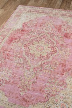 a pink and beige rug with an ornate design on the middle, in a room