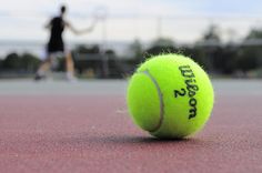 a tennis ball sitting on top of a tennis court