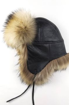 A fluffy hat that will always amaze by its beauty. A regal hat produced for warm-lovers and generally for those who want something majestical to bedeck their head with the most outstanding and massive way. An aviator style hat made with black napa sheepskin and extra heavy long-haired finn Raccoon skin. It has earflaps that can be adjusted to any high with leather straps that can be tied under the chin, on top of hat and at back of the head. Product description: 100% handmade product Natural mat Faux Fur Winter Hat With Ear Flaps, Winter Faux Fur Hats With Ear Flaps, Warm Faux Fur Hats With Ear Flaps, Sheepskin Hat With Faux Fur Lining And Ear Flaps, Winter Black Sheepskin Hats, Winter Hats With Faux Fur Trim And Ear Flaps, Winter Hats With Faux Fur Lining, Winter Aviator Hat With Plush Lining, Winter Sheepskin Hats With Plush Lining