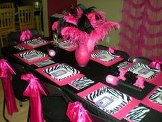 the table is decorated with zebra print and pink decorations, along with matching napkins