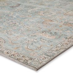 an antique rug with blue and beige colors on the floor, close - up view