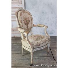 an old fashioned chair sitting on top of a wooden floor in front of a wall